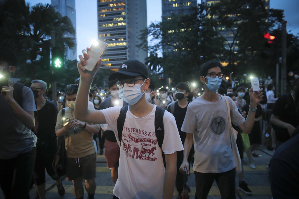 Pro-democracy demonstrators march holding their phones with flashlights on during a protest to mark the first anniversary of a mass rally against the now-withdrawn extradition bill in Hong Kong, Tuesday, June 9, 2020. One year ago, a sea of humanity a million people by some estimates marched through central Hong Kong on a steamy afternoon. It was the start of what would grow into the longest-lasting and most violent anti-government movement the city has seen since its return to China in 1997. (AP Photo/Kin Cheung)