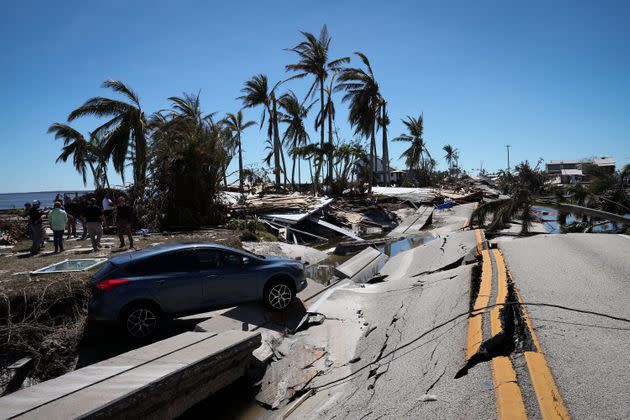 The wreckage of a car teeters on a buckled roadway in the wake of Hurricane Ian on Sept. 30 in Matlacha. (Photo: Win McNamee via Getty Images)