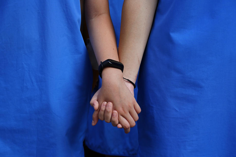 Students form human chain outside St. Paul's Co-Educational College in Hong Kong, Monday, Sept. 9, 2019. Students and alumni of the school protest to pressure the government to meet four demands following a formal withdrawal of the controversial extradition Bill. (AP Photo/Vincent Yu)