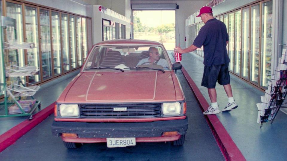 San Luis Drive Thru manager Brad Hays serves up a cool drink to Pete Lawn of San Luis Obispo in Aug. 13, 1998.