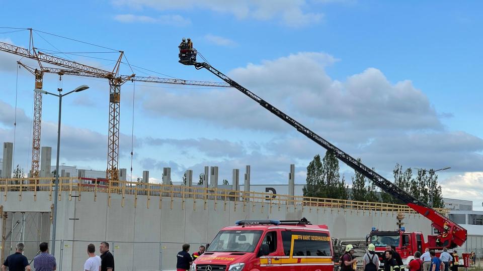 Feuerwehrleute mit einer Drehleiter sind an der Baustelle im Einsatz, wo das Unglück geschah.