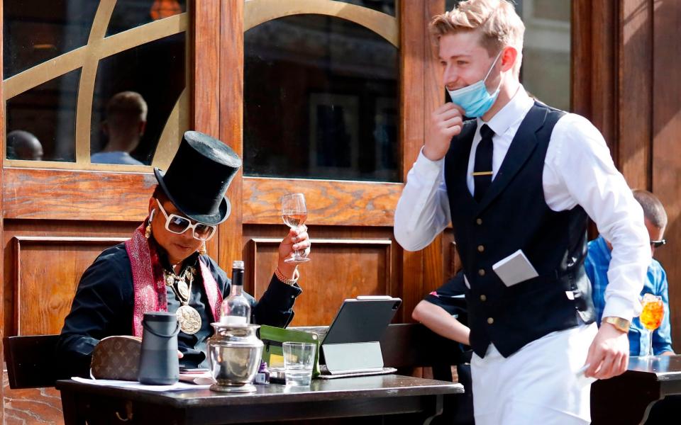 A waiter wears a face mask on the first day of the Eat Out to Help Out discount scheme - Tolga Akmen/AFP