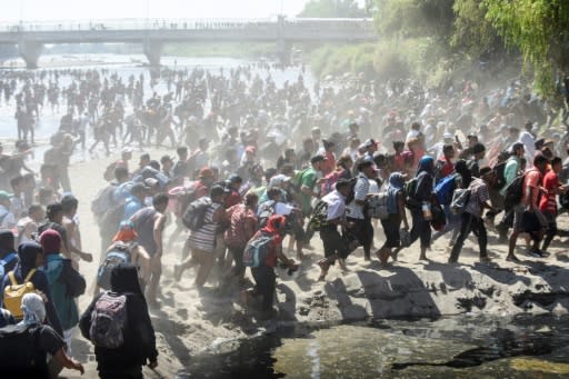 Central American migrants - mostly Hondurans travelling in caravan to the US - cross the Suchiate River, the natural border between Guatemala and Mexico, on January 20