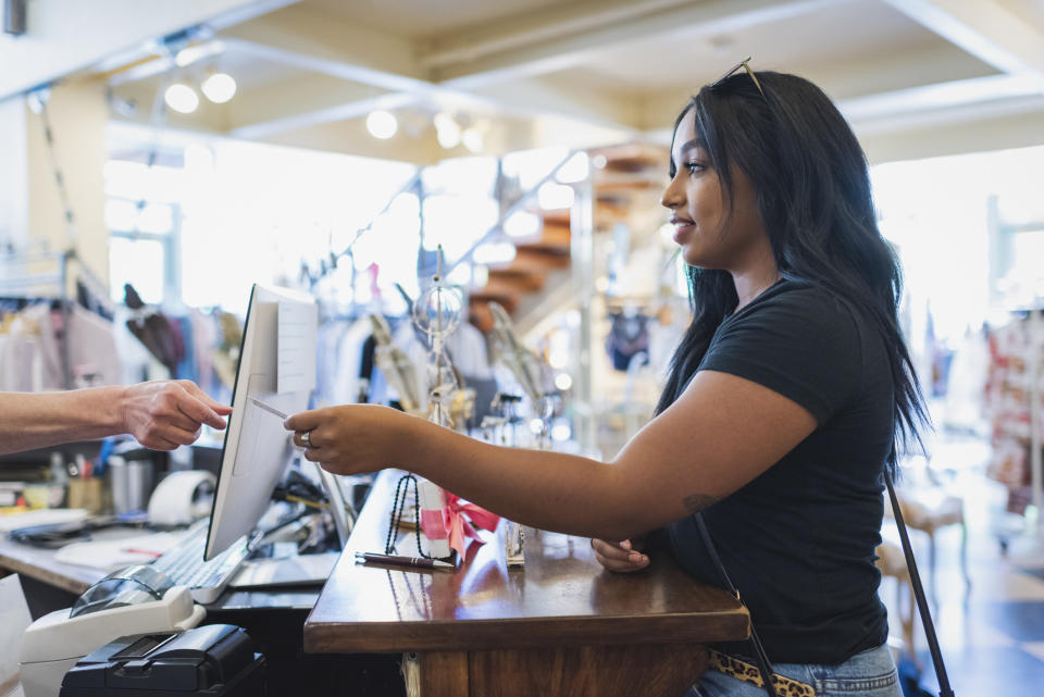 A woman passing a sales associate her credit card