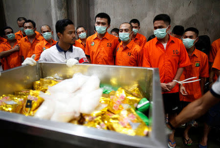 FILE PHOTO: Drug suspects watch as recently confiscated narcotics, including 1.4 tonnes methamphetamine and a large amount of ecstasy pills, are wheeled to an incinerator by police following a ceremony by drug enforcement agencies in Jakarta, Indonesia August 15, 2017. REUTERS/Darren Whiteside/File Photo