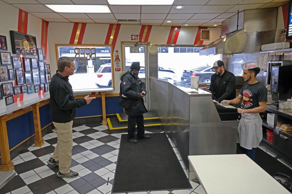 Customers, keeping their distance from one another, wait to pick up food at the famous American Coney Island diner in Detroit. Under Whitmer's order, restaurants can stay open, exclusively for take-out, but nonessential businesses must close. (Photo: SETH HERALD via Getty Images)