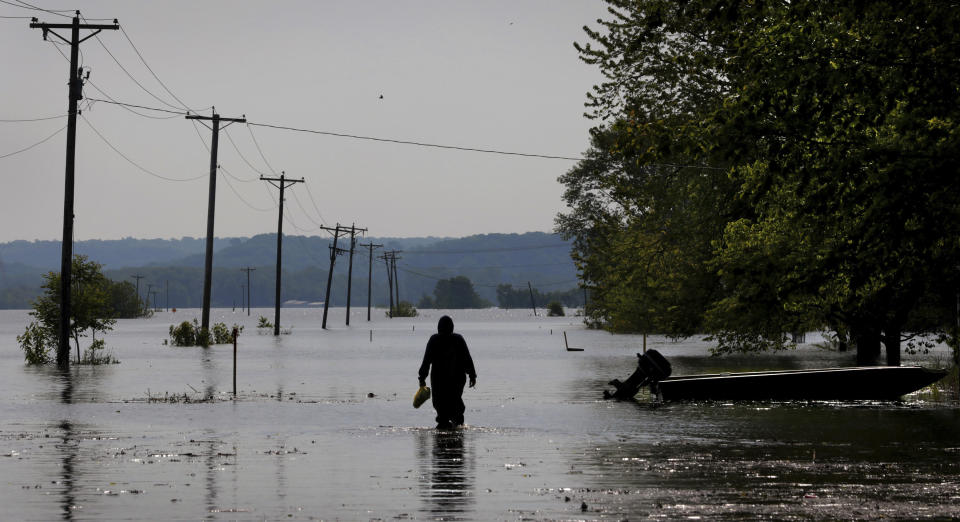 A resident who declined to be identified wades through Mississippi River floodwater to his Winfield home on Friday, May 24, 2019. The river is scheduled to crest for a third time late next week. (Robert Cohen/St. Louis Post-Dispatch via AP)