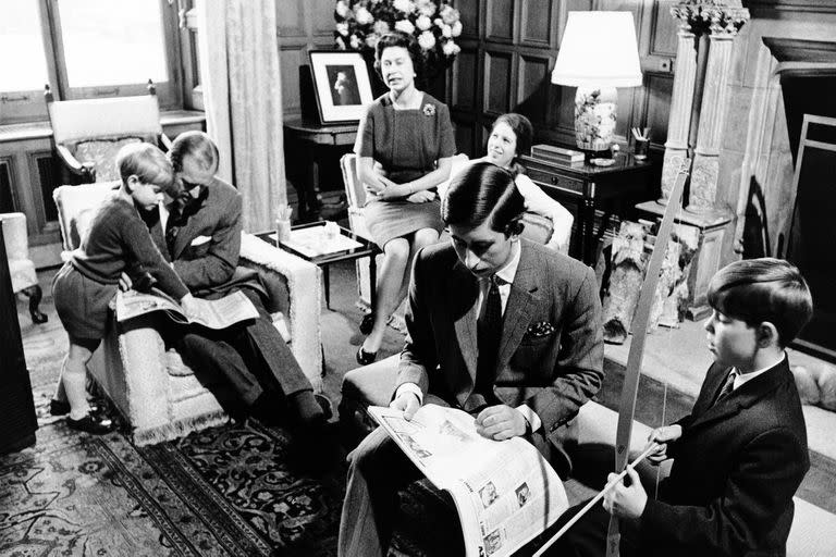 La Reina Isabel II de Gran Bretaña, al fondo, al centro, y el Príncipe Felipe sentados con sus hijos, el Príncipe Eduardo, a la izquierda, la Princesa Ana, al fondo, el Príncipe Carlos, en primer plano y el príncipe Andrés, a la derecha en Sandringham House, en Sandringham, Inglaterra, en 1969