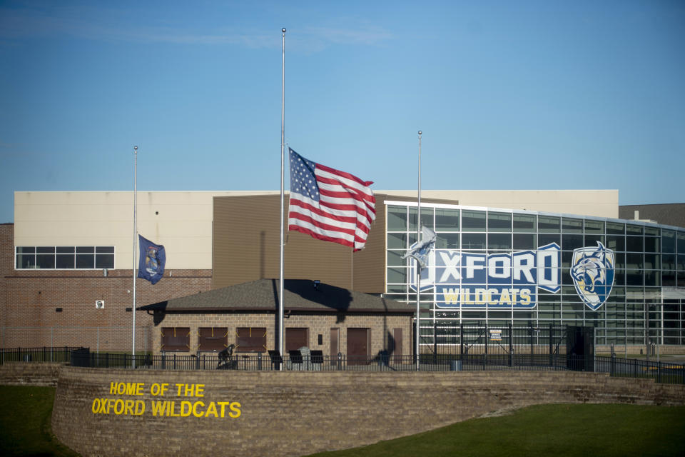 FILE - The American flag flies at half-staff on Thursday, Dec. 2, 2021, outside of Oxford High School in Oxford, Mich. Officials planned to welcome students back to Oxford High School on Monday, Jan. 24, 2022, which is reopening for the first time since four students were killed and six students and a teacher were injured during a shooting at the school on Nov. 30, 2021. The students have been attending classes at other buildings since Jan. 10. A fellow student, Ethan Crumbley, 15, is charged with murder and other crimes. His parents also are facing charges. (Jake May/The Flint Journal via AP, File)
