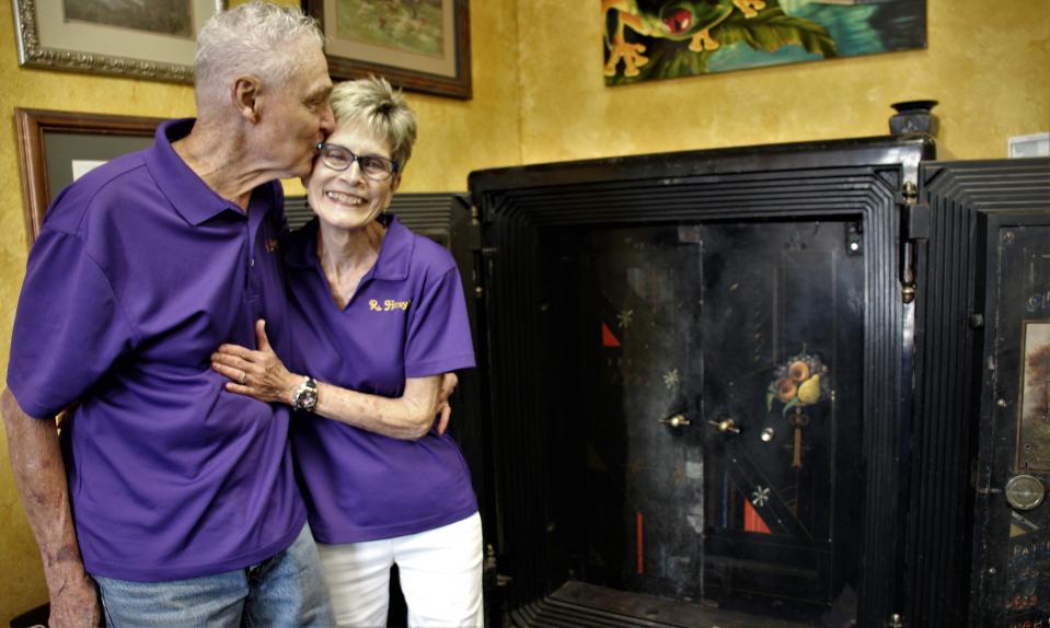 Percy Parsons plants a kiss on his honey of almost 29 years, Holly, next to the huge floor safe on wheels in their shop. The Parsons have closed the business to retire.