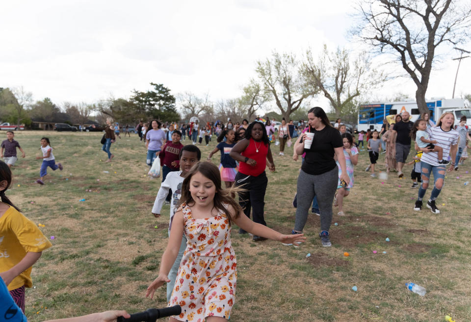 Children run to collect toy prizes as the rain begins at  Shi Lee's 7th annual Citywide Easter Egg Hunt  Sunday at Bones Hooks Park in Amarillo.