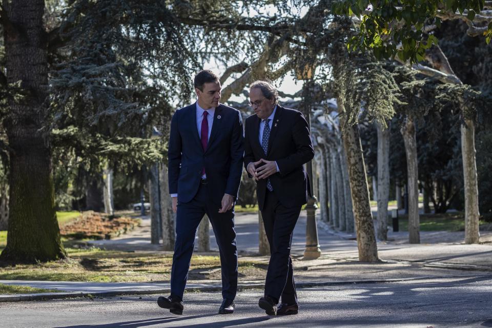 Spanish Prime Minister Pedro Sanchez, left, walks with Catalan regional President Quim Torra at the Moncloa palace in Madrid, Spain, Wednesday, Feb. 26, 2020. Spain's prime minister and the leader of Catalonia are opening formal talks Wednesday in hopes of resolving the festering political crisis provoked by the region's separatist movement. (AP Photo/Bernat Armangue)