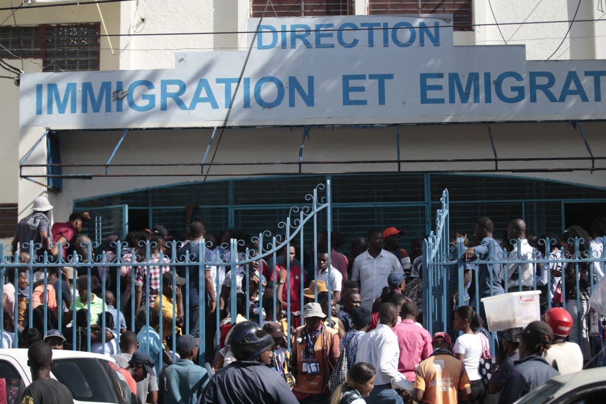 Haitians line up outside an immigration office as they wait their turns to apply for a passport, in Port-au-Prince, Haiti, Tuesday, Jan. 10, 2023. (AP Photo/Odelyn Joseph)