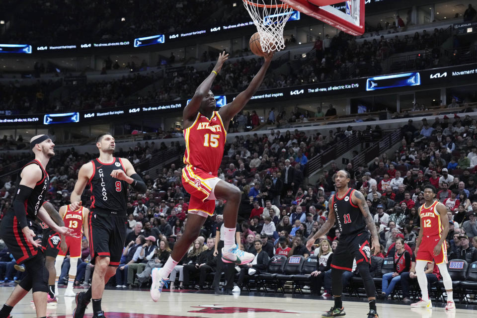 Atlanta Hawks center Clint Capela, right, drives to the basket past Chicago Bulls guard Alex Caruso, left, and center Nikola Vucevic during the first half of an NBA basketball game in Chicago, Monday, April 1, 2024. (AP Photo/Nam Y. Huh)