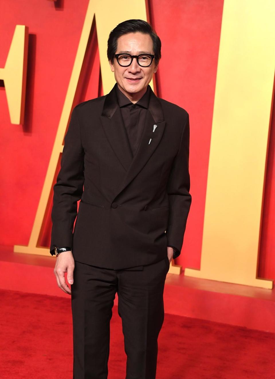 ke huy quan wearing a black suit at the vanity fair oscars after party