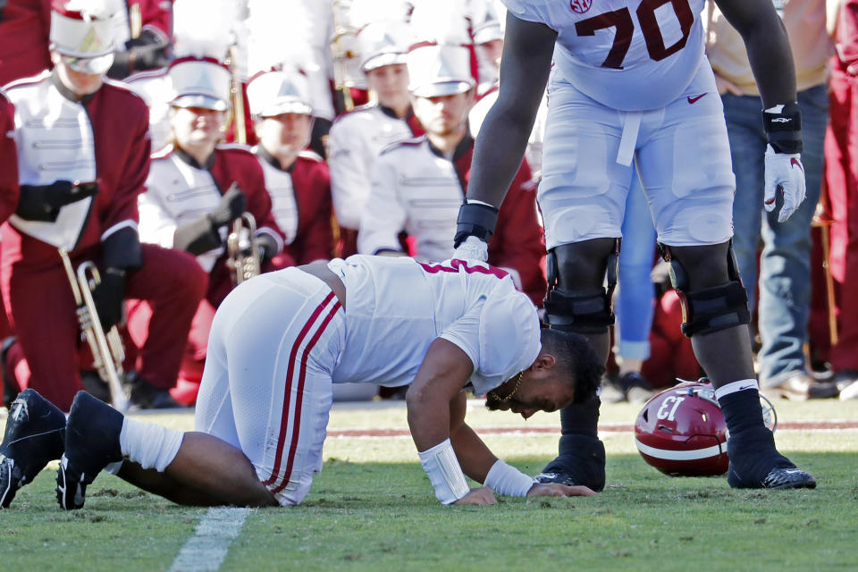 Alabama sive lineman Alex Leatherwood (70) checks on quarterback Tua Tagovailoa (13) after he was injured in the first half of an NCAA college football game against Mississippi State in Starkville, Miss., Saturday, Nov. 16, 2019. Alabama won 38-7. (AP Photo/Rogelio V. Solis)