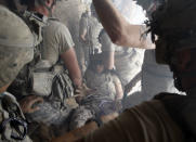 <p>A U.S. soldier, wounded by sniper fire, is evacuated by his comrades in the village of Bargematal, Nuristan province, Aug. 25, 2009. (Photo: Oleg Popov/Reuters) </p>