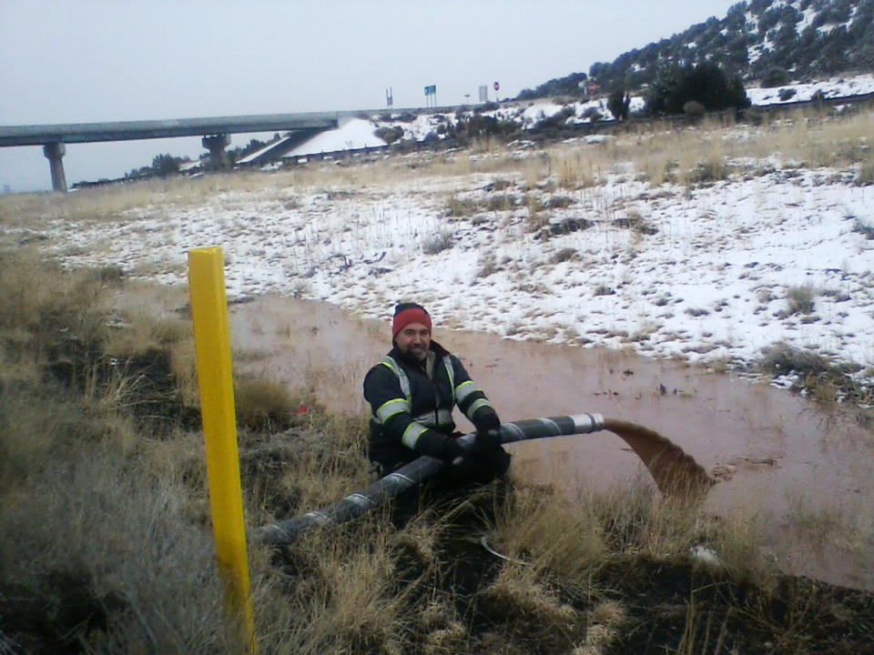 This Monday, Jan. 14, 2019 photo provided by the Arizona Department of Public Safety shows a worker pouring gallons of chocolate that spilled from an overturned truck at the scene of the wreck about 11 miles east of Flagstaff, Ariz. A tank trucker’s trailer detached from the truck and rolled on its side on slick pavement, spilling a river of liquid chocolate onto westbound lanes of Interstate 40. Department of Public Safety spokesman Bart Graves said the wreck required cleanup crews to pour most of the 40,000 gallons (151,412 liters) of chocolate into the highway median to lighten the damaged tanker so it could be towed away. The DPS said there were no injuries and the driver was not cited. (Arizona DPS via AP)