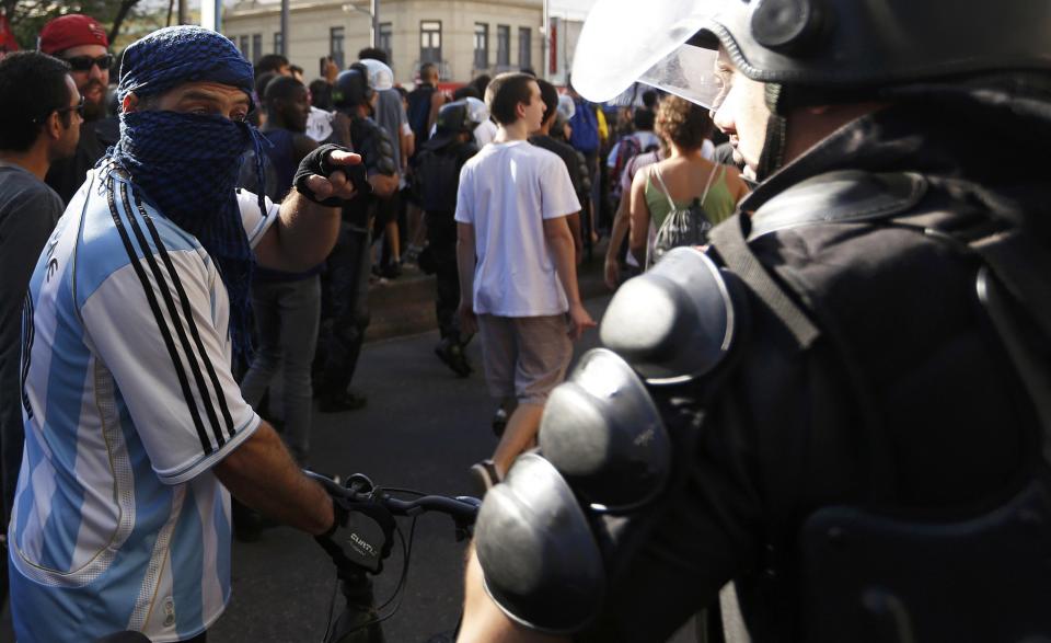 A demonstrator wears an Argentina national team jersey as he argues with a policeman before the 2014 World Cup final match between Argentina and Germany in Rio de Janeiro, July 13, 2014. REUTERS/Marco Bello (BRAZIL - Tags: POLITICS SOCCER CRIME LAW SPORT CIVIL UNREST WORLD CUP)