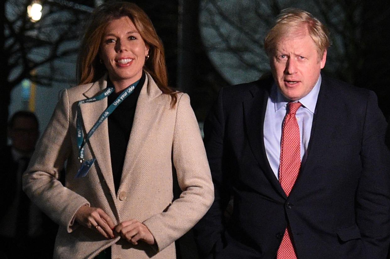 Britain's Prime Minister and Conservative leader Boris Johnson (R) and his partner Carrie Symonds (L) arrive at the count centre in Uxbridge, west London, on December 13, 2019 as votes were counted as part of the UK general election. - Prime Minister Boris Johnson's ruling party appeared on course for a sweeping victory in Thursday's snap election, an exit poll showed, paving the way for Britain to leave the EU next month after years of political deadlock. (Photo by Oli SCARFF / AFP) (Photo by OLI SCARFF/AFP via Getty Images)