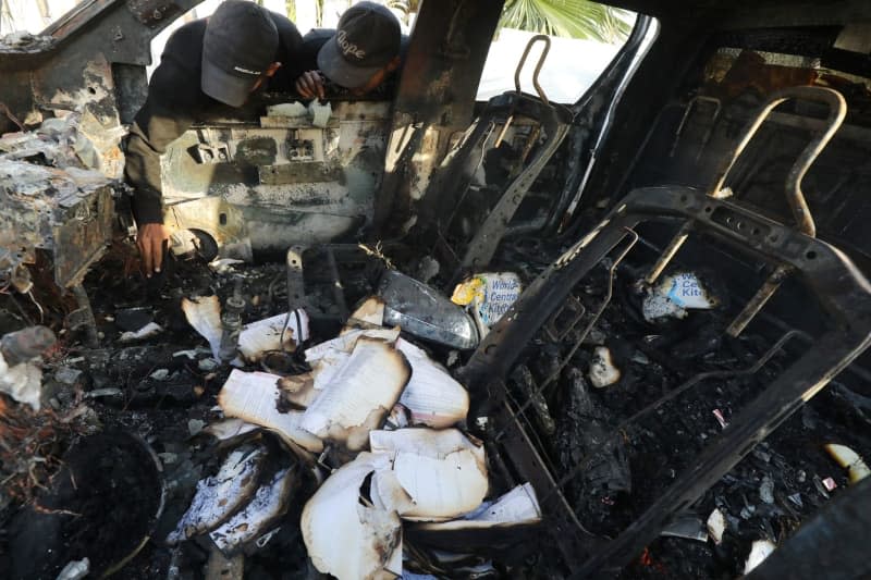 Palestinians inspect the heavily damaged vehicle following Israeli attacks targeting officials working at the US-based international volunteer aid organization World Central Kitchen (WCK).  Omar Ashtawy/APA Image via ZUMA Press Wire/dpa