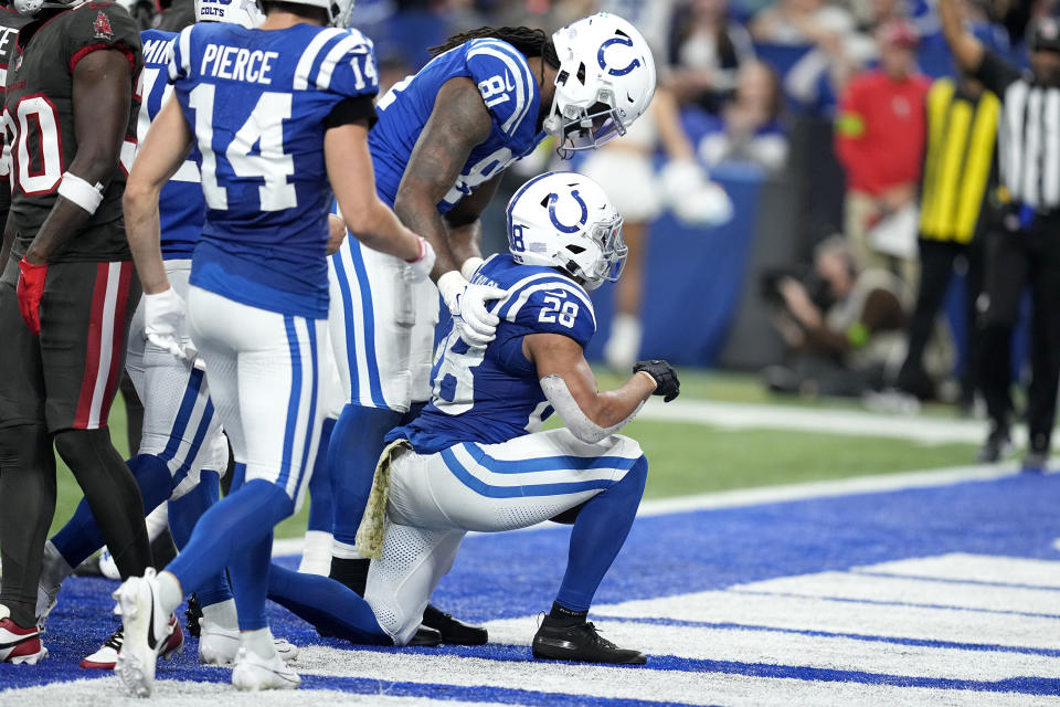 Indianapolis Colts running back Jonathan Taylor (28) kneels as he celebrates his touchdown with teammates during the second half of an NFL football game against the Tampa Bay Buccaneers Sunday, Nov. 26, 2023, in Indianapolis. (AP Photo/Darron Cummings)