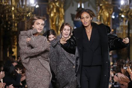 Models Cara Delevingne (L) and Joan Smalls (R) present creations by British designer Stella McCartney as part of her Fall/Winter 2014-2015 women's ready-to-wear collection show during Paris Fashion Week March 3, 2014. REUTERS/Benoit Tessier