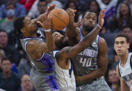 Sacramento Kings' De'Aaron Fox, left, and Harrison Barnes guard Dallas Mavericks guard Kyrie Irving during the second half of an NBA basketball game in Sacramento, Calif., Friday, Feb. 10, 2023. The Mavericks won 122-114. (AP Photo/Randall Benton)