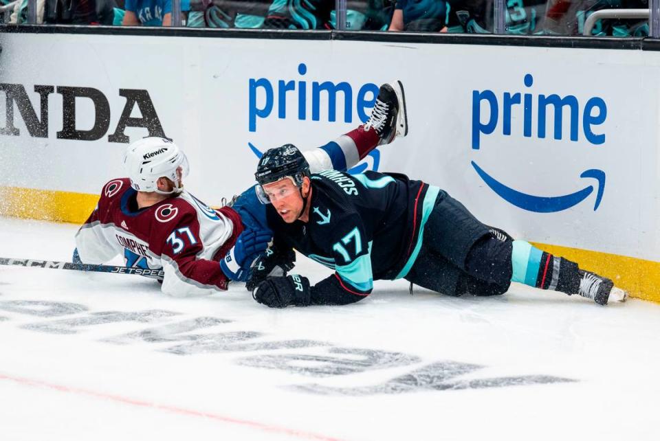 Seattle Kraken center Jaden Schwartz (17) and Colorado Avalanche left wing J.T. Compher (37) fall onto the ice after batting for the puck during the third period of a first round 2023 Stanley Cup Playoffs game against the Colorado Avalanches at Climate Pledge Arena in Seattle on Saturday, April 22, 2023. The Seattle Kraken lost 4-6 to the Colorado Avalanches.