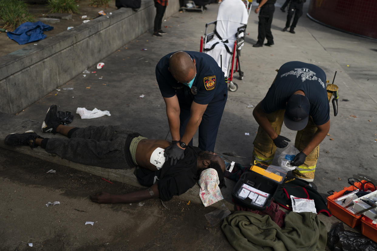 A paramedic performs CPR on a homeless man, who collapsed after a physical altercation over a coat with another homeless person, in Los Angeles, Wednesday, July 27, 2022. The 33-year-old man died of asphyxia and neck compression, according to his autopsy report. Nearly 2,000 homeless people died in the city from April 2020 to March 2021, a 56% increase from the previous year, according to a report released by the Los Angeles County Department of Public Health. (AP Photo/Jae C. Hong)