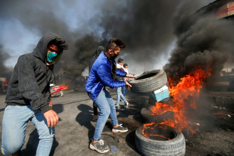 Manifestantes iraquíes queman neumáticos durante las protestas antigubernamentales en Basora