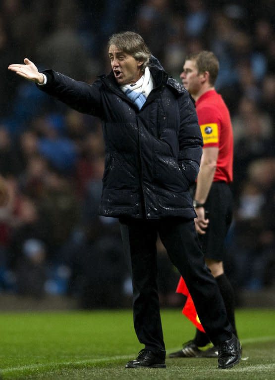 Manchester City's manager Roberto Mancini gestures to his players during their Premiership football match against Reading at The Etihad stadium in Manchester, northwest of England on December 22, 2012. Mancini admits Manchester City's bid to catch Premier League leaders Manchester United may prove a heart-stopping affair after the champions' dramatic 1-0 win against Reading