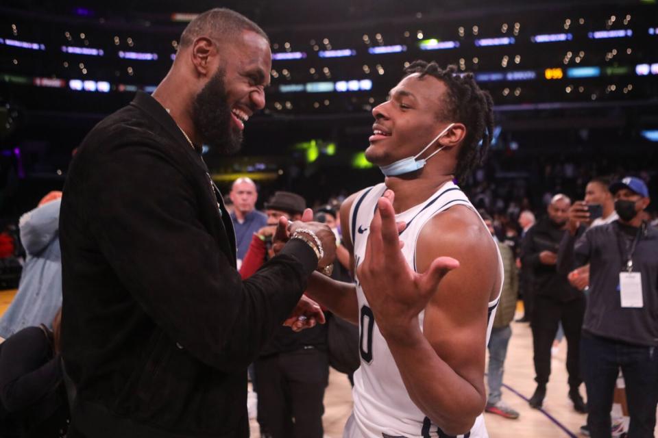 LeBron James congratulates his son Bronny on the Crypto.com Arena court.