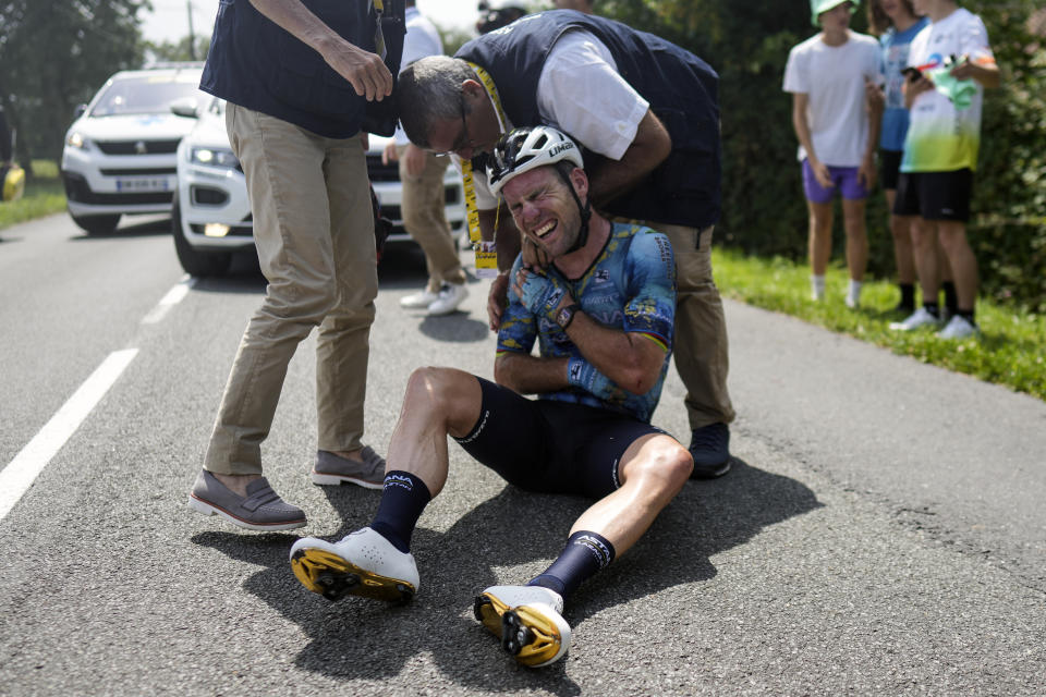 FILE - Britain's Mark Cavendish grimaces in pain as he receives medical assistance after crashing during the eighth stage of the Tour de France cycling race over 201 kilometers (125 miles) with start in Libourne and finish in Limoges, France, Saturday, July 8, 2023. (AP Photo/Thibault Camus, File)