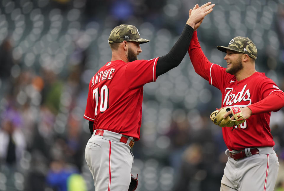 Cincinnati Reds relief pitcher Tejay Antone, left, congratulates center fielder Nick Senzel after the ninth inning of a baseball game against the Colorado Rockies, Sunday, May 16, 2021, in Denver. (AP Photo/David Zalubowski)