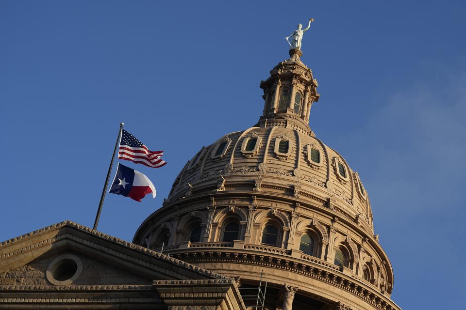 The U.S. and Texas flags fly over the Capitol.