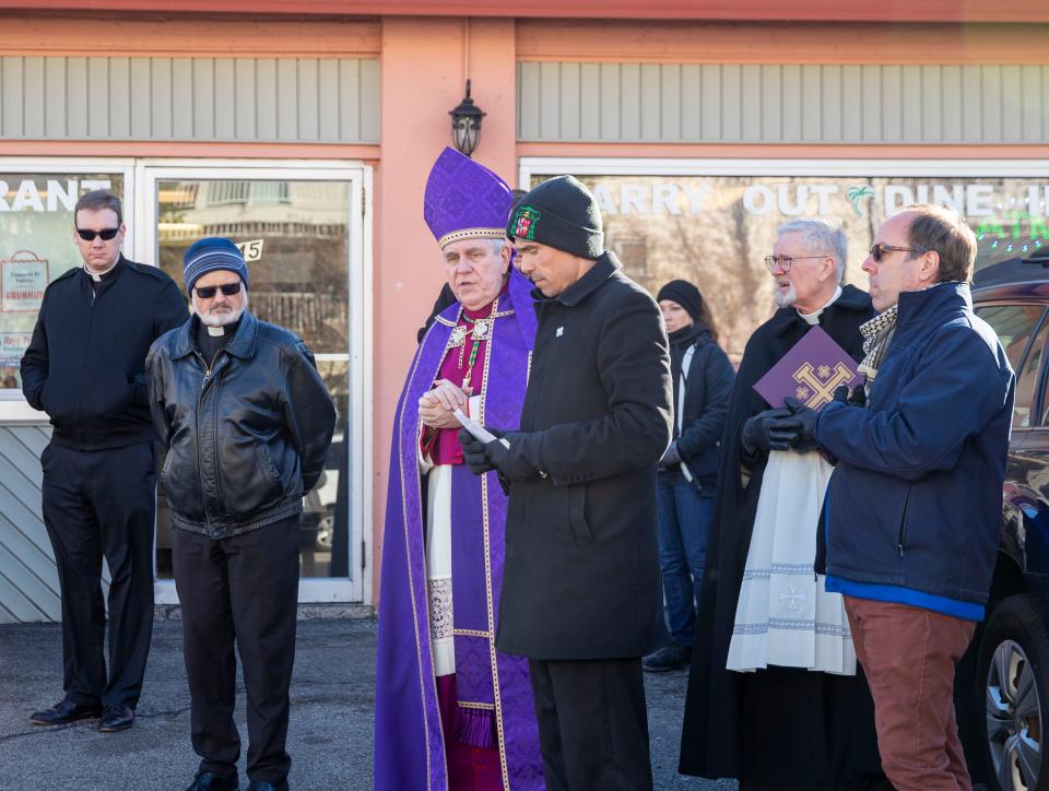 Milwaukee Archbishop Jerome E. Listecki, center left, and Father Matthew Widder, center right, make a stop along the procession route on Main Street to say a few prayers Sunday in Waukesha.