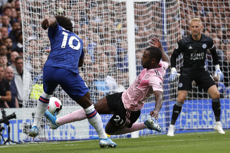 El jugador del Leicester, Ricardo Pereira (21), intenta bloquear el tiro del jugador del Chelsea, Willian (10), durante un partido de la Liga Premier inglesa en el estadio Stamford Bridge en Londres, el domingo 18 de agosto de 2019. (AP Foto/Frank Augstein)