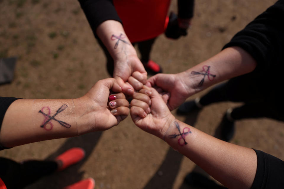 Miembros de un equipo de remo de botes dragón para mujeres con cáncer de mama y sobrevivientes reman durante una sesión de entrenamiento en una laguna en las afueras de Santiago, Chile, el 24 de julio de 2022. (REUTERS/Ivan Alvarado)