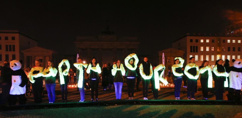 WWF activists form the words "Earth Hour 2014" in front of the Brandenburger Tor gate during Earth Hour in Berlin