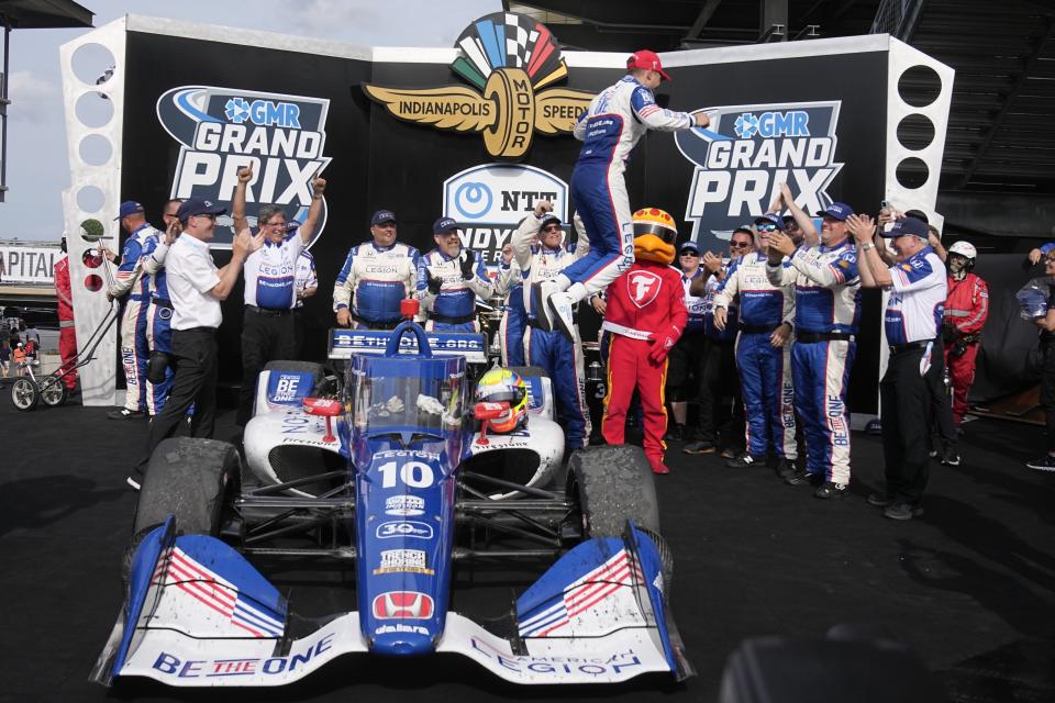 Alex Palou, of Spain, jumps from his car after winning the IndyCar Grand Prix auto race at Indianapolis Motor Speedway, Saturday, May 13, 2023, in Indianapolis. (AP Photo/Darron Cummings)