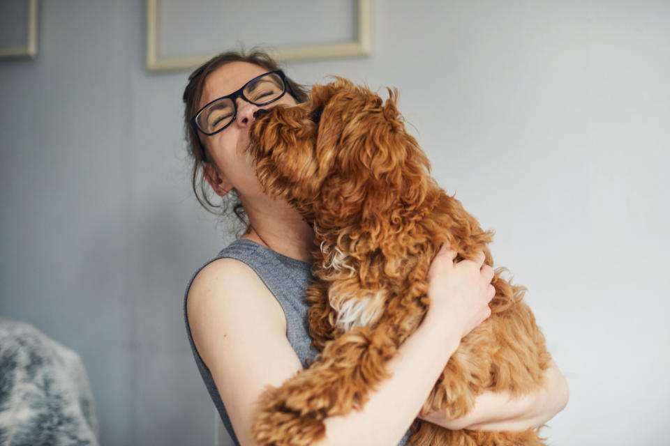 A person receiving kisses from a dog