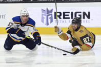 St. Louis Blues left wing Jaden Schwartz (17) and Vegas Golden Knights defenseman Shea Theodore (27) dive for the puck during the first period of an NHL hockey game Saturday, May 8, 2021, in Las Vegas. (AP Photo/David Becker)