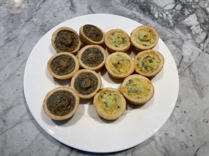 12 mini quiche duos on a plate. Six of the quiches are dark brown and the other six are a lighter tan color