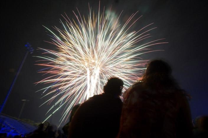 Spectators watch the East Providence fireworks display from the grass at Pierce Field in East Providence in 2015. East Providence will again have a show this year.