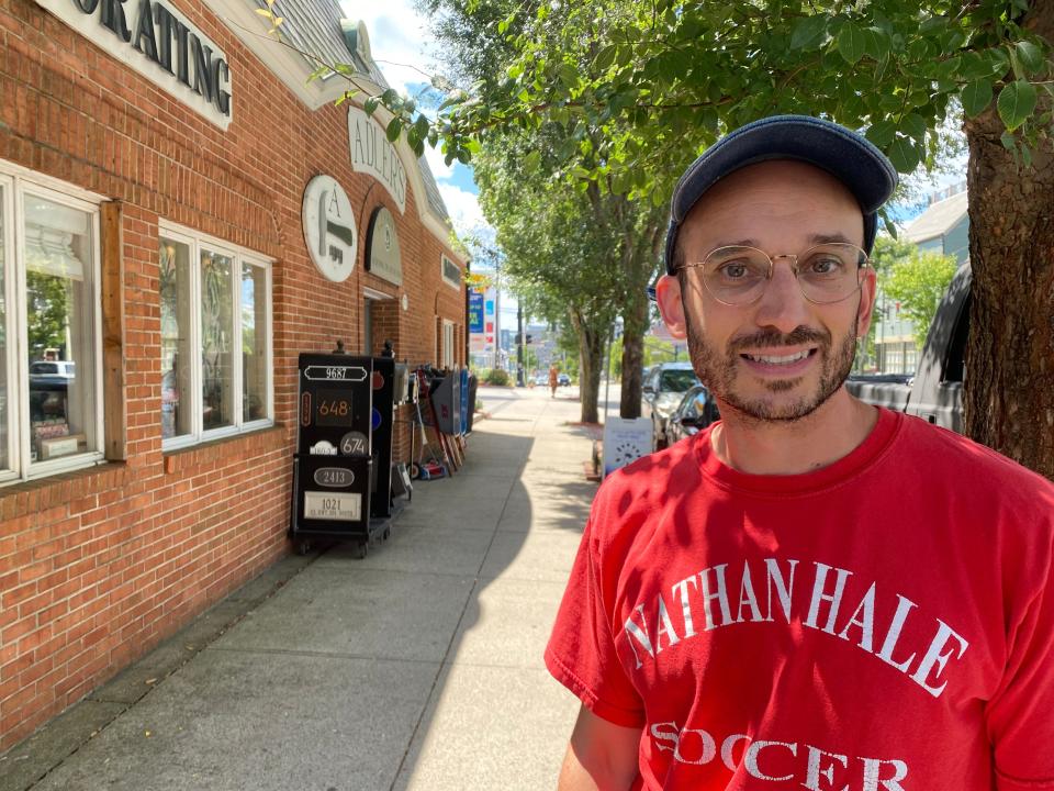 Nicolas Heliotis, a Brown University graduate student, pauses on Wickenden Street in Providence Wednesday, near where Trader Joe's plans to open a store this year, making his walk to buy groceries much shorter.
