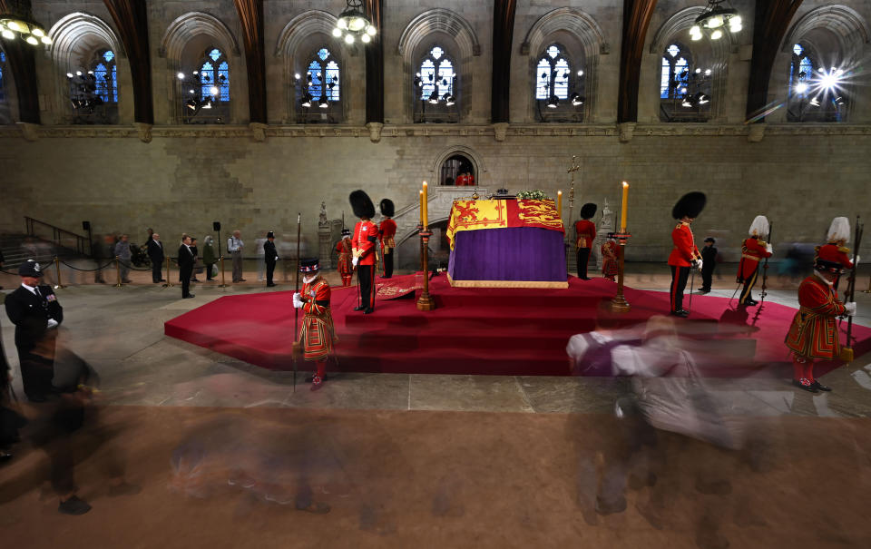 Members of the public file past, as soldiers of The Grenadier Guards and Yeomen of the Guard, stand guard around the coffin of Queen Elizabeth II, inside Westminster Hall, , London, as members of the public pay their respects as the vigil begins, where it will lie in state ahead of her funeral on Monday. Picture date: Wednesday September 14, 2022.