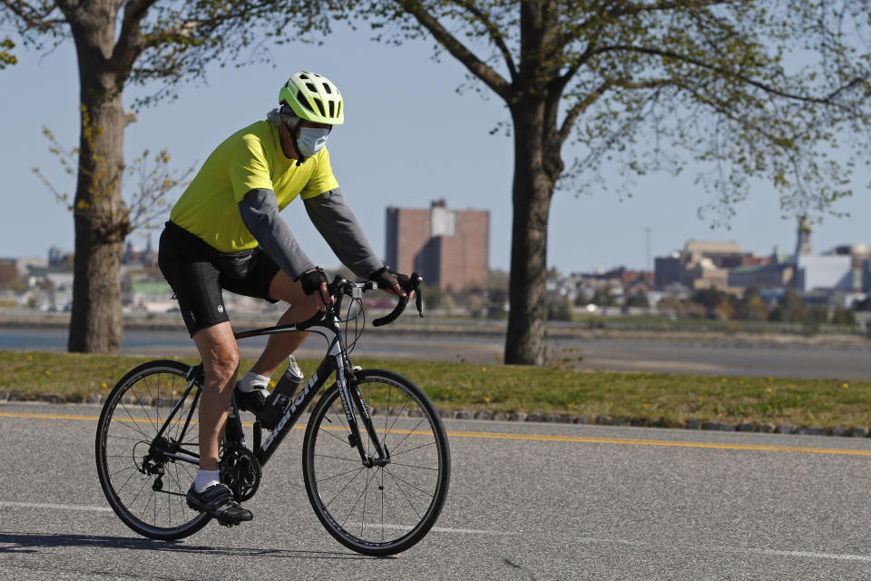 FILE-In this May 20, 2020 photo, a bicyclist wears a pandemic mask while riding in Portland, Maine. A bicycle rush kicked off mid-March around the time countries were shutting their borders, businesses were closing and stay-at-home orders were being imposed because of the coronavirus pandemic in which millions have been infected and nearly 400,000 have died. (AP Photo/Robert F. Bukaty)