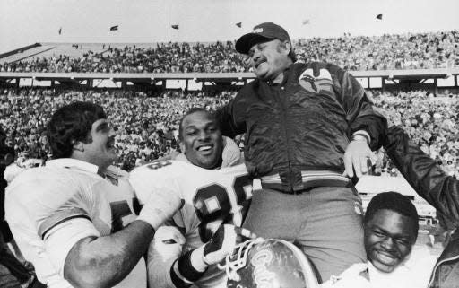 Florida head coach Galen Hall is carried off the field by players Rodney Billett (left), Duncan Parham (center) and James Massey after Florida defeated Kentucky 25-17 to secure at least a tie in the Southeastern Conference title game on November 17, 1984 in Lexington.