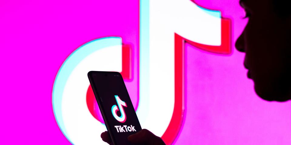 TikTok's logo appears in a pink background behind a silhouette of a person holding a phone.